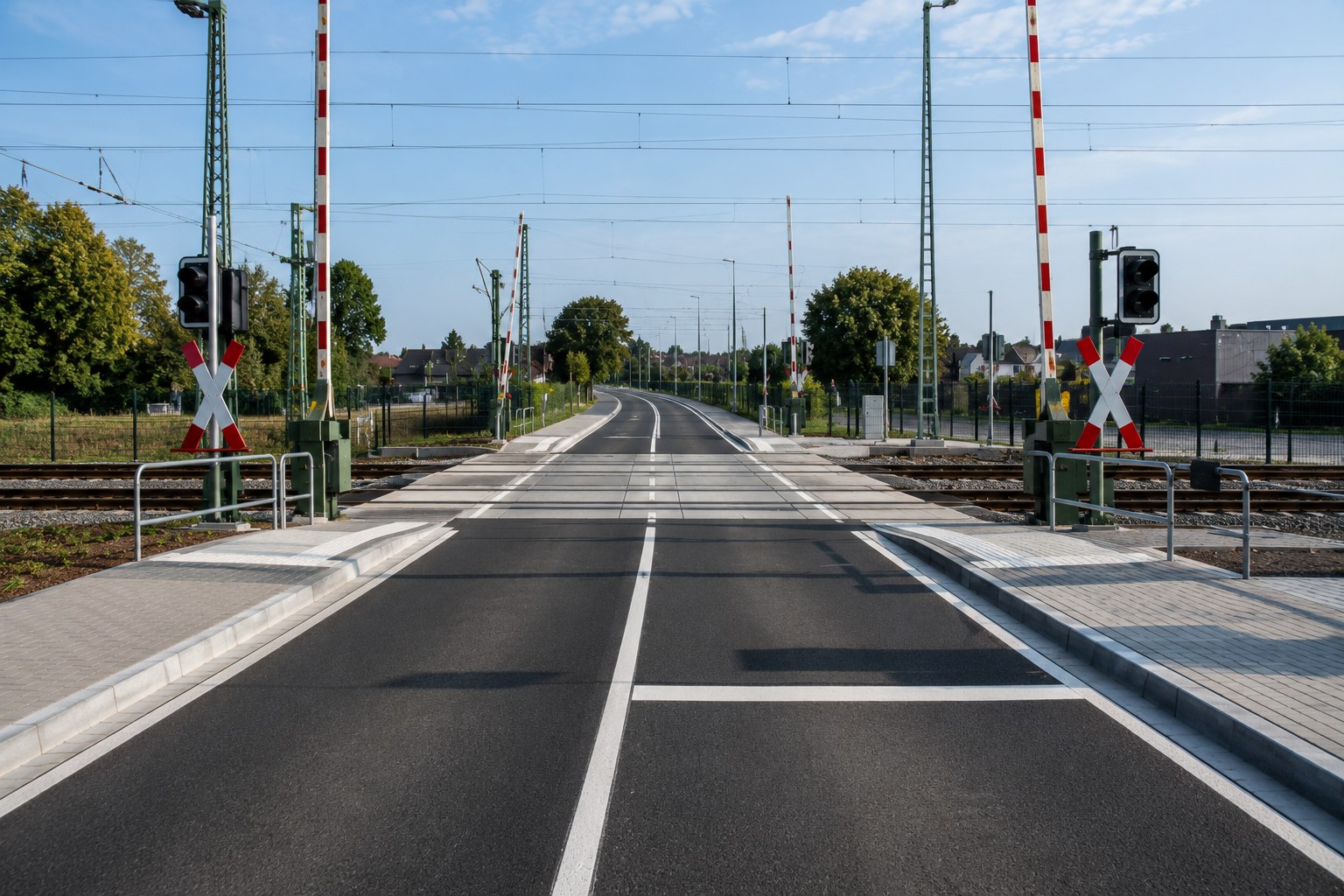 Fertiger Bahnübergang mit neuer Fahrbahn, Schranken und Markierung